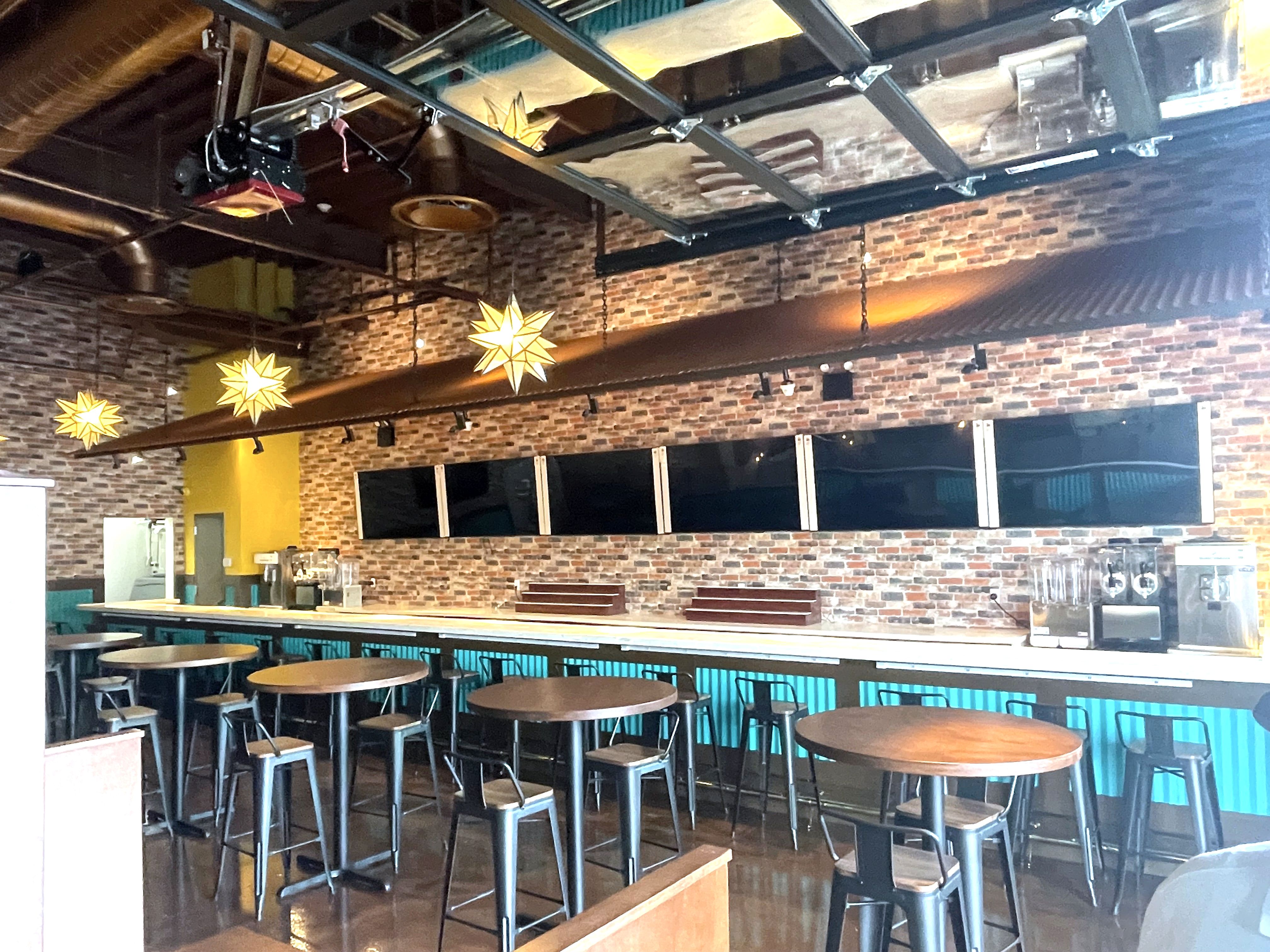 Restaurant bar with brick wall, stools and star pendant lights